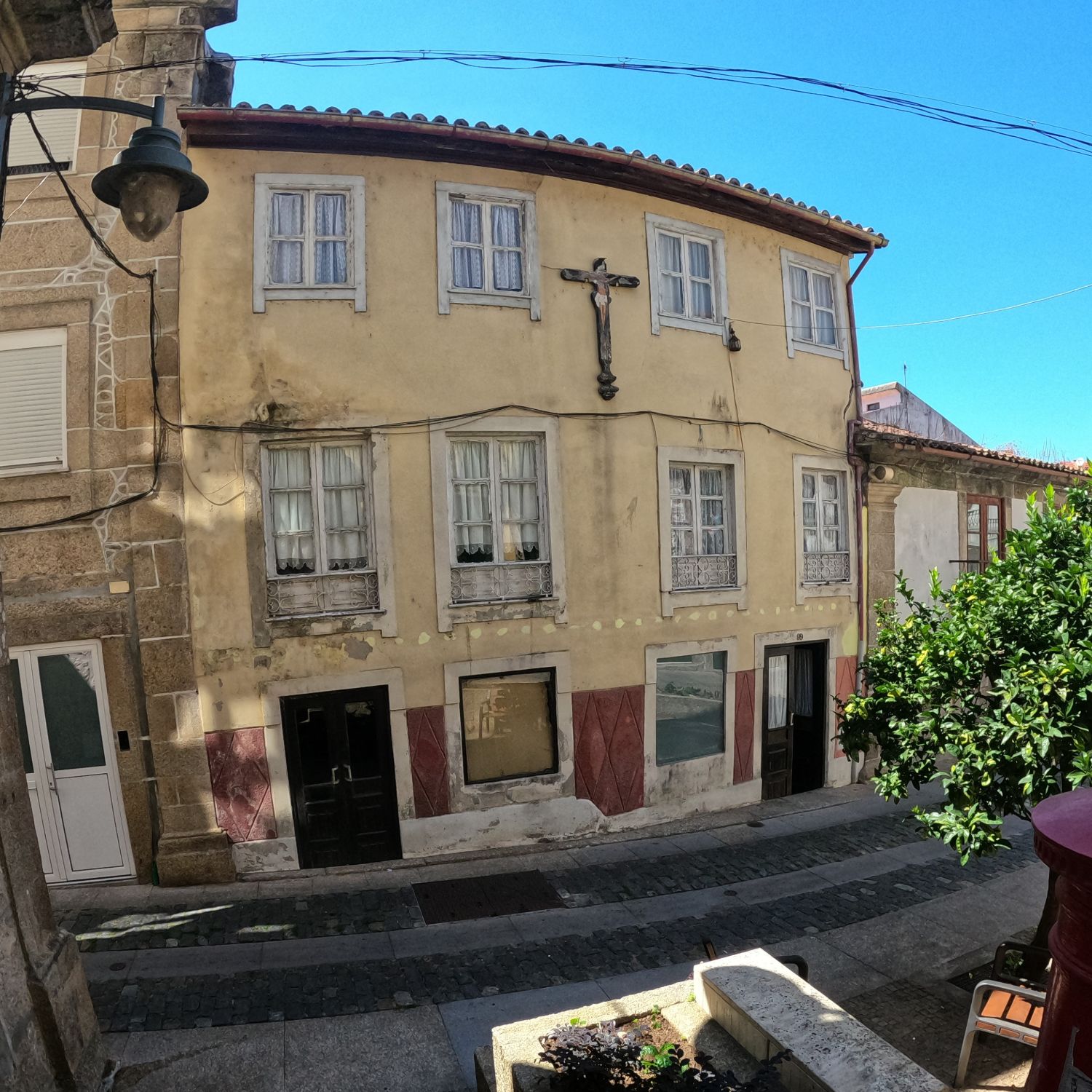 A fachada ocre de três pisos da casa no Largo da Valeta, com duas portas para a rua